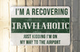 a green and white sign that says i'm a recovering travelaholic