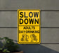 a yellow slow down sign on the side of a building