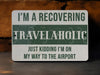 a green and white sign that says i'm a recovering travelaholic