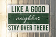 a green and white sign that says like a good neighbor stay over there