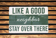 a green and white sign that says like a good neighbor stay over there