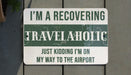 a sign on a wooden fence that says, i'm a recovering travelah