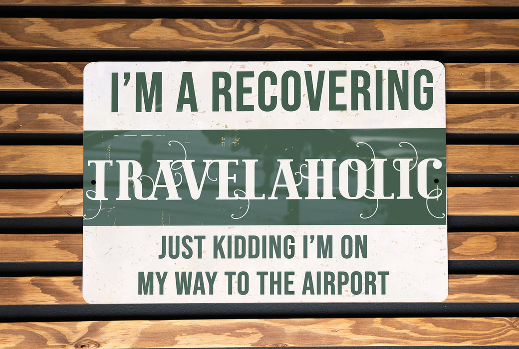 a sign on a wooden bench that says i'm a recovering travelaholic