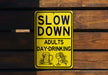 a yellow slow down sign on a wooden wall