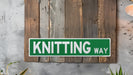 a green and white sign that says knitting way