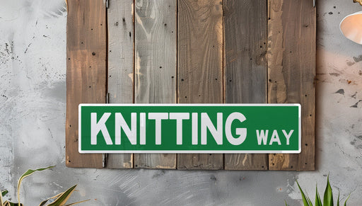a green and white sign that says knitting way