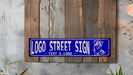 a blue street sign hanging on a wooden wall