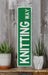 a green street sign sitting on top of a wooden shelf