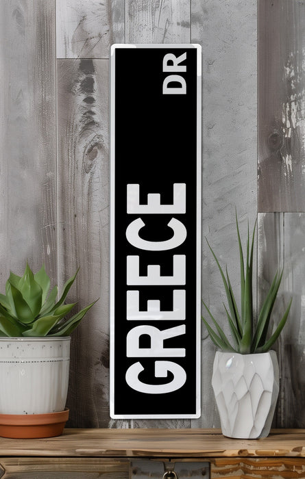 a black and white sign sitting on top of a wooden shelf