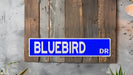 a blue street sign mounted to a wooden wall
