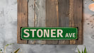 a green stoner ave sign mounted to a wooden wall