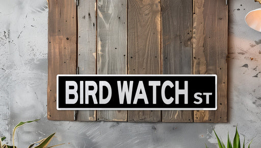 a bird watch street sign mounted to a wall