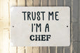 a white sign that says trust me i'm a chef