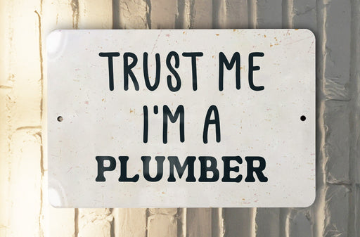 a white sign that says trust me i'm a plumber