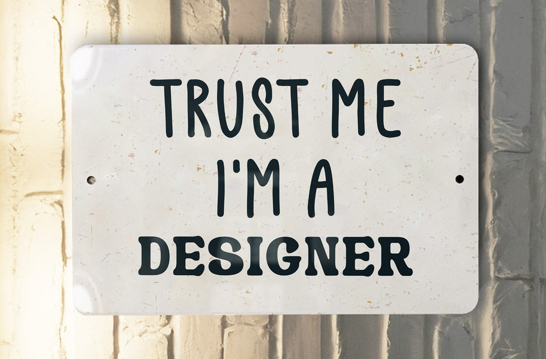 a white sign that says trust me i'm a designer