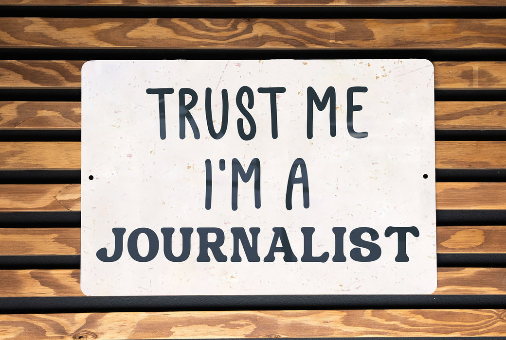 a white sign that says trust me i'm a journalist