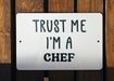 a white sign that says trust me i'm a chef