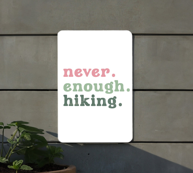 a sign that says never enough hiking next to a potted plant