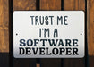 a white sign that says trust me i'm a software developer