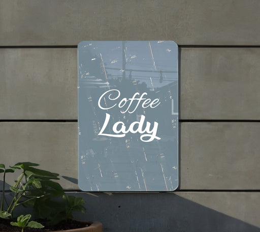 a sign that reads coffee lady next to a potted plant