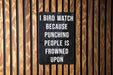 a sign on a wooden wall that says, i bird watch because punching people is