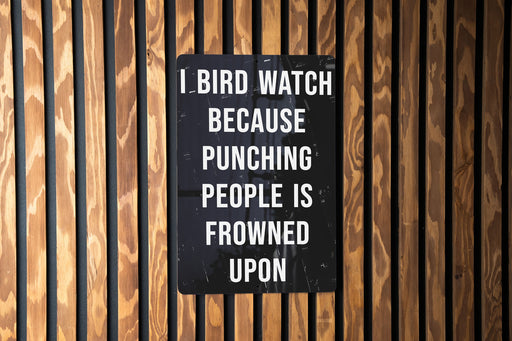 a sign on a wooden wall that says, i bird watch because punching people is