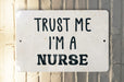 a white sign that says trust me i'm a nurse