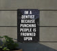 a sign on a wall that says i'm a dentist because punching people is