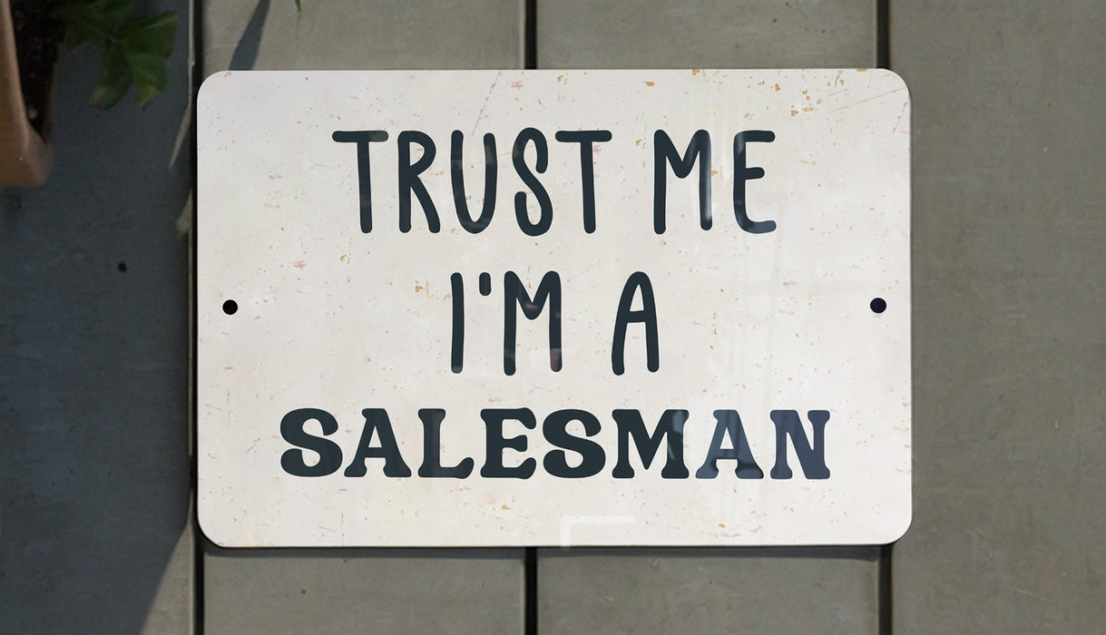 a white sign that says trust me i'm a salesman