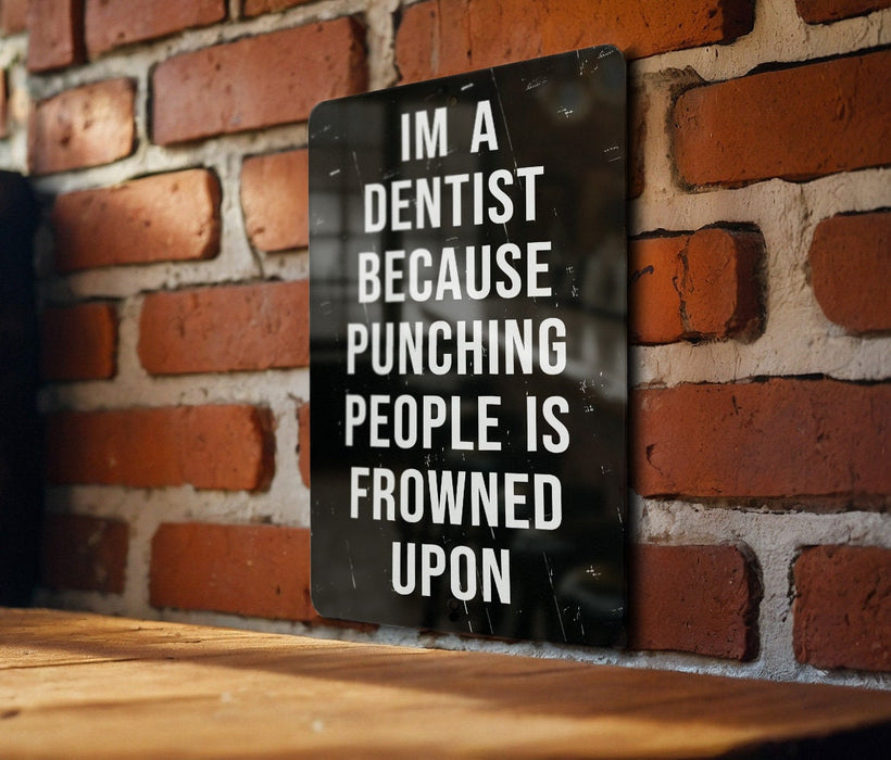 a sign on a brick wall that says i'm a dentist because punching people