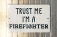 a white sign that says trust me i'm a firefighter