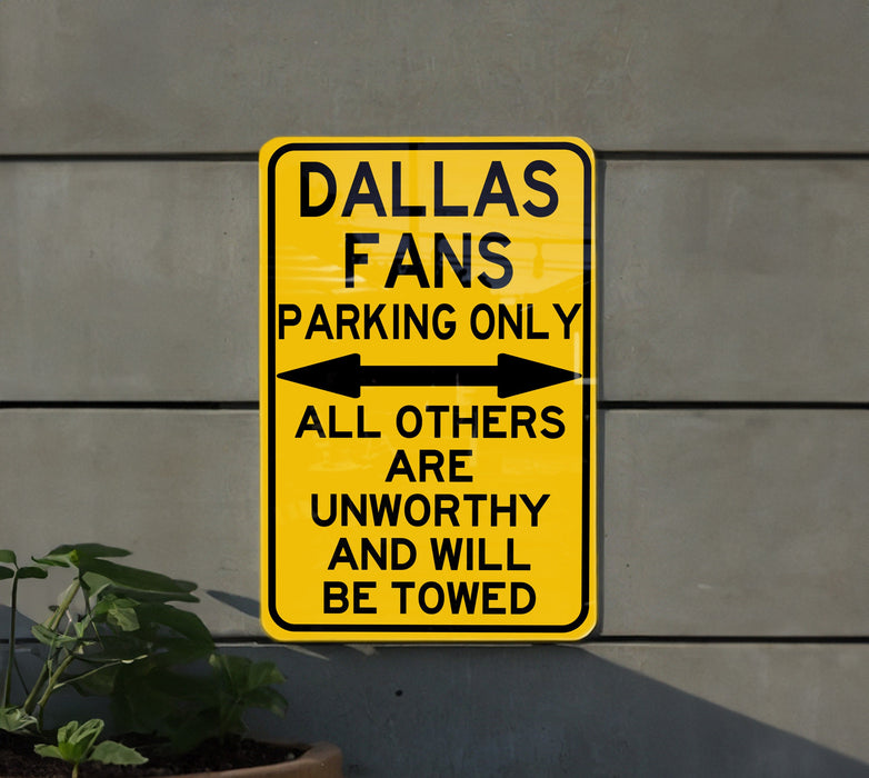 a yellow sign that says, dallas fans parking only all others are unworthyly
