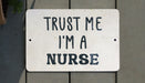 a white sign that says trust me i'm a nurse