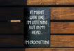 a sign on a wooden bench that says it might look like i'm listening