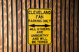 a yellow and black sign on a wooden fence