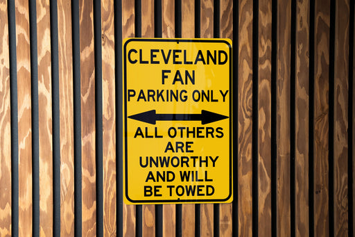 a yellow and black sign on a wooden fence
