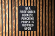 a sign on a wooden wall that says i'm a firefighter because punching