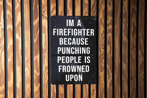 a sign on a wooden wall that says i'm a firefighter because punching