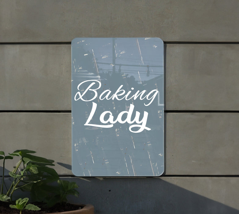 a sign that says baking lady next to a potted plant