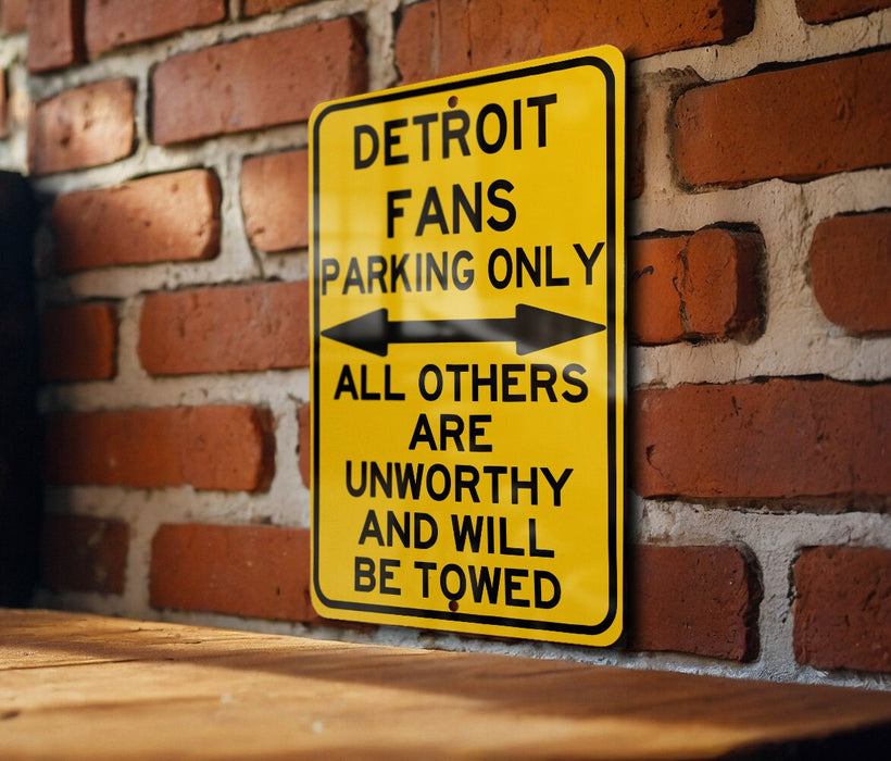 a yellow sign on a brick wall that says detroit fans parking only all others are