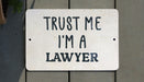 a white sign that says trust me i'm a lawyer