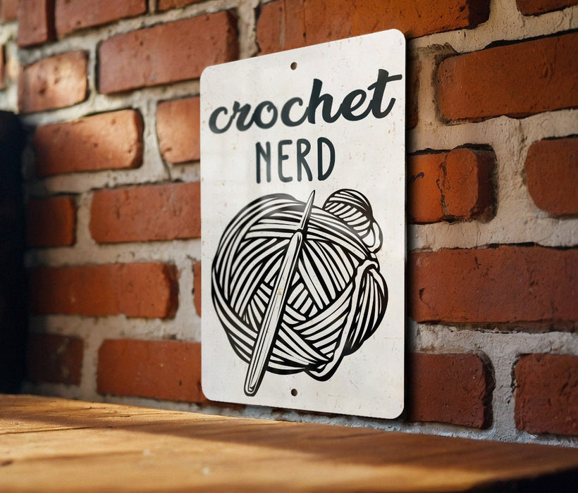 a sign on a brick wall that says crochet nerd