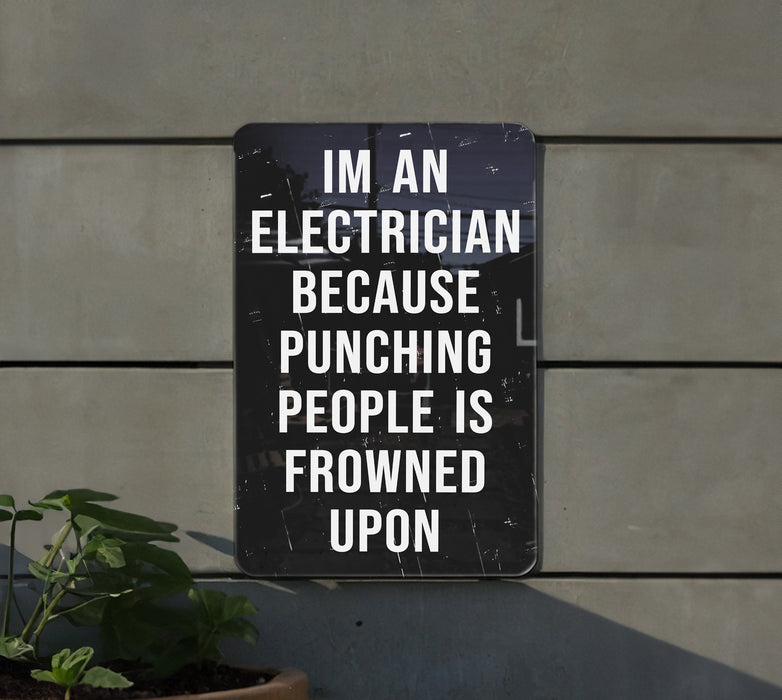 a sign on a wall that says i'm an electrician because punching people