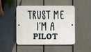 a white sign that says trust me i'm a pilot
