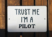 a white sign that says trust me i'm a pilot