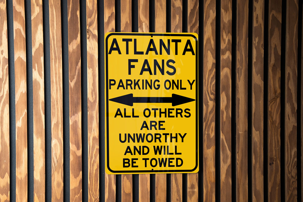a yellow street sign on a wooden fence