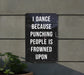 a sign on the side of a building that says i dance because punching people is