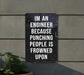 a sign on a wall that says i'm an engineer because punching people is
