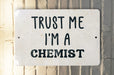a white sign that says trust me i'm a scientist