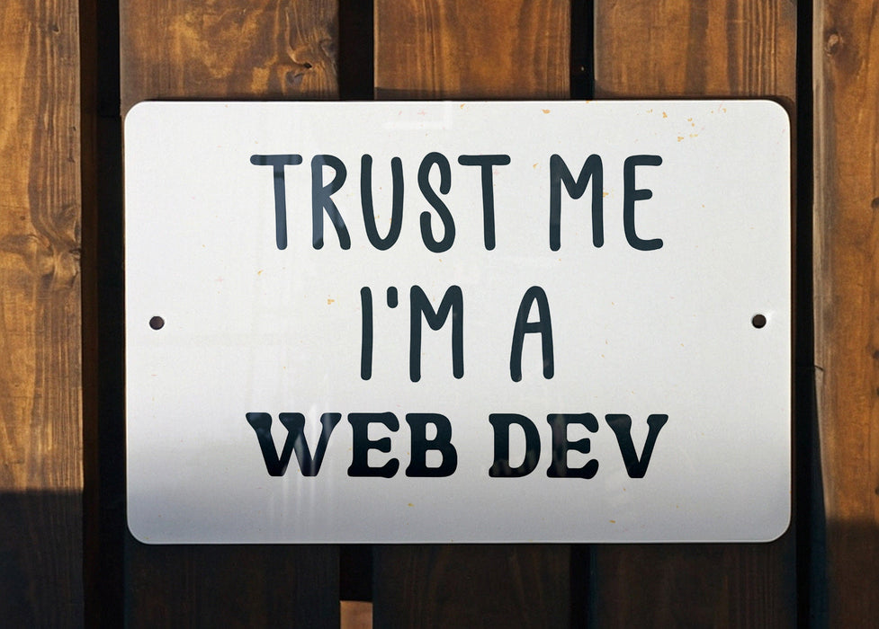 a white sign that says trust me i'm a web dev